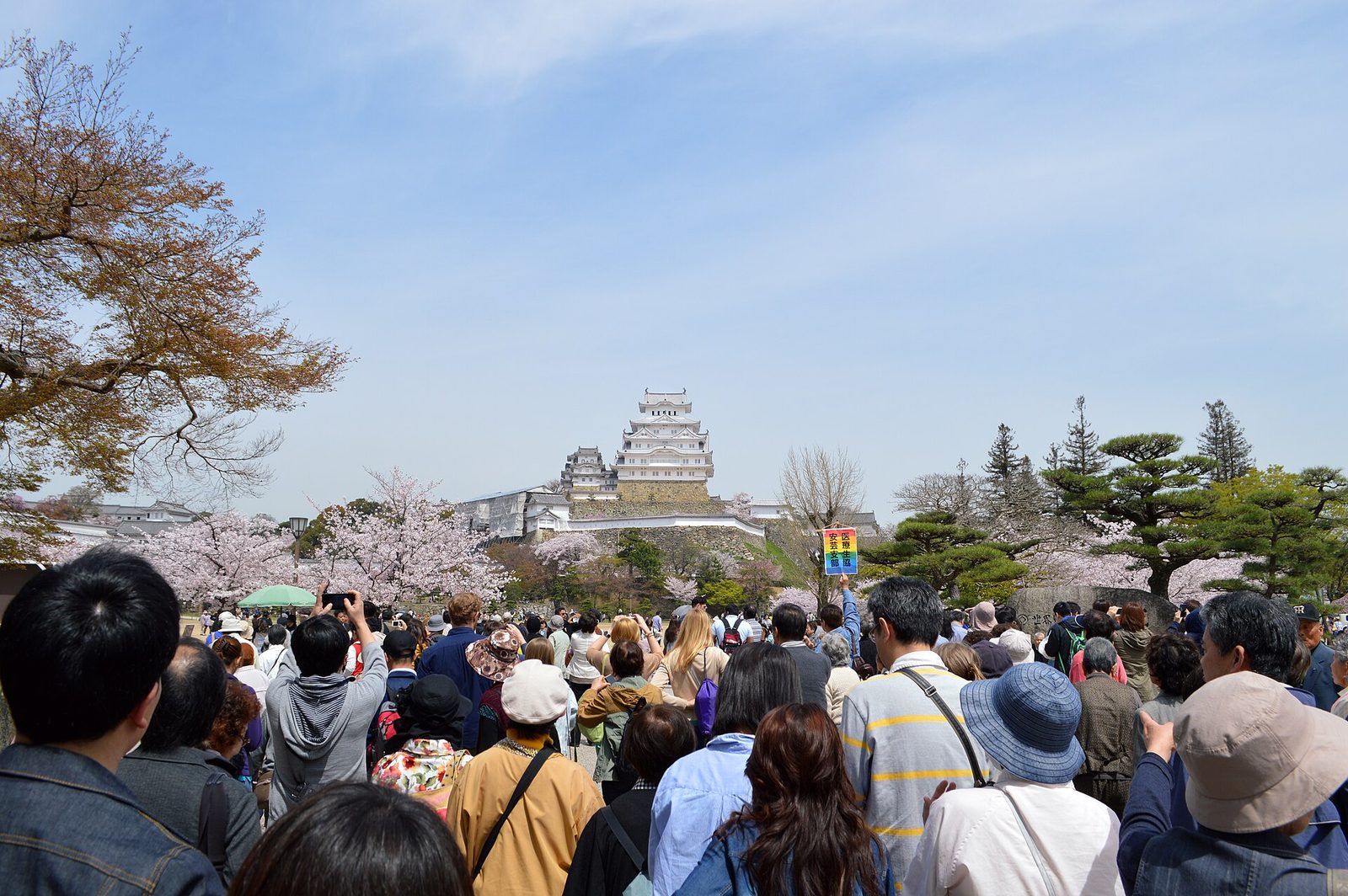 Visitors walking the broad approach toward Himeji Castle on a clear day
